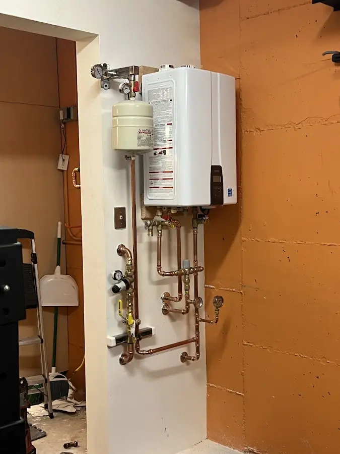 Plumbing technician inspecting water heater connections in Colesville